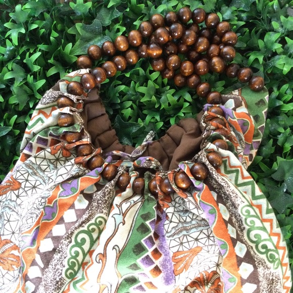 Reversible hobo tote with brown wood balls straps. Has a tie strap closure. - Picture 4 of 10